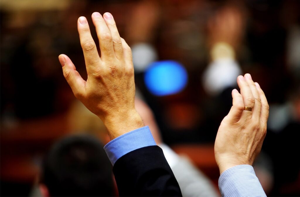 Raised hands in a meeting or conference.
